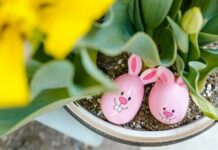 Two pink Easter eggs nestled in a tulip pot.