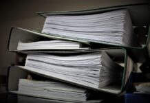 A stack of several thick binders full of papers