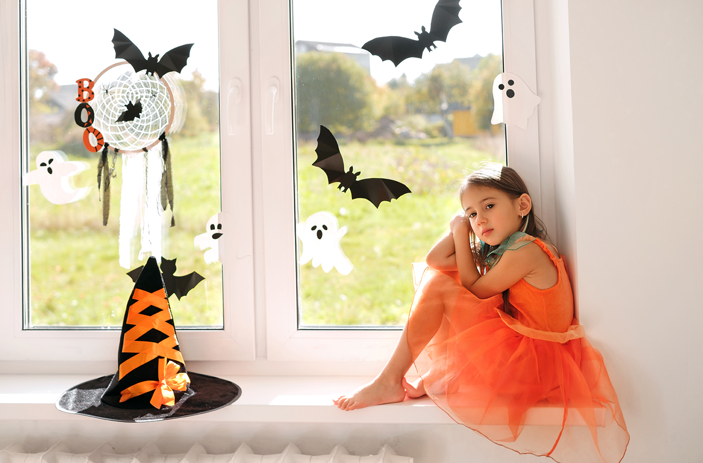 A Girl Is Sitting On The Windowsill Waiting For Halloween.