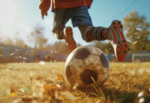 A child runs away from a muddy soccer ball.