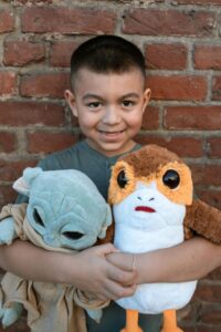 Young boy holds Star Wars plushies