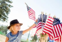 Independence Day Fun in the Delaware Valley Child taking an American flag from a bunch of flags