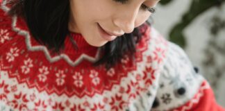 Person putting a candy cane in hot chocolate