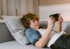 Boy laying on couch using a smartphone
