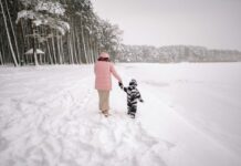 Keeping Kids Safe When the Temperature Drops A parent leading a child through the snow