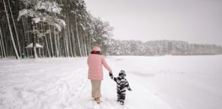 A parent leading a child through the snow