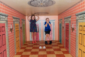 Children in a room in the Please Touch Museum designed to make them look really big