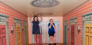 Children in a room in the Please Touch Museum designed to make them look really big