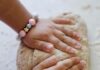 A child's hands kneading bread dough
