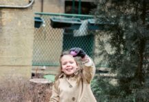 A girl holds up an Easter egg and a basket