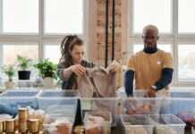 Two people sorting through donated clothes