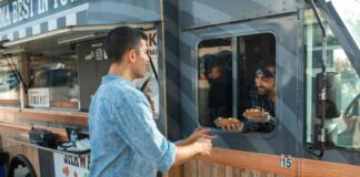 Man getting hot dogs from a food truck