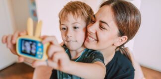 Mother and child take a selfie with a toy camera inside