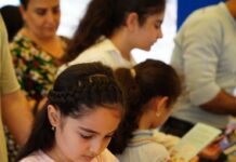 Girl reading a book at a book sale